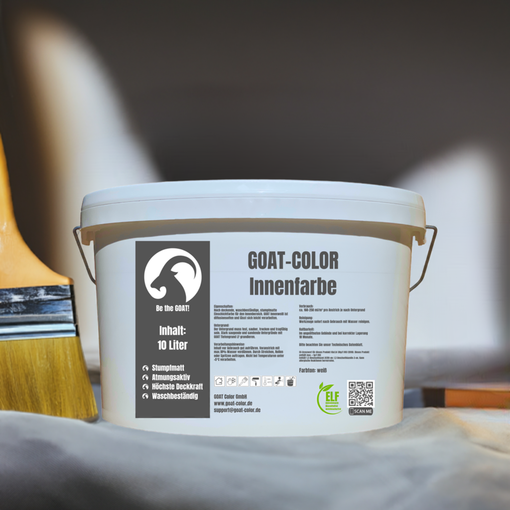 Eimer GOAT-Color Innenfarbe in Weiß, 10 Liter, stumpfmatt mit höchster Deckkraft und waschbeständig, ideal für den Innenbereich. Im Vordergrund ein Pinsel auf einer Malerunterlage